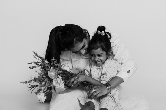 Image of a woman holding a child with flowers in her hands
