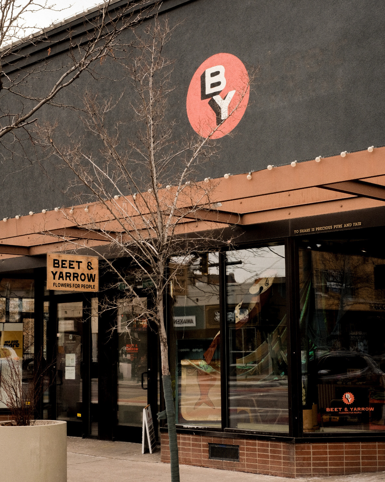  storefront with 'BY' logo on a dark wall